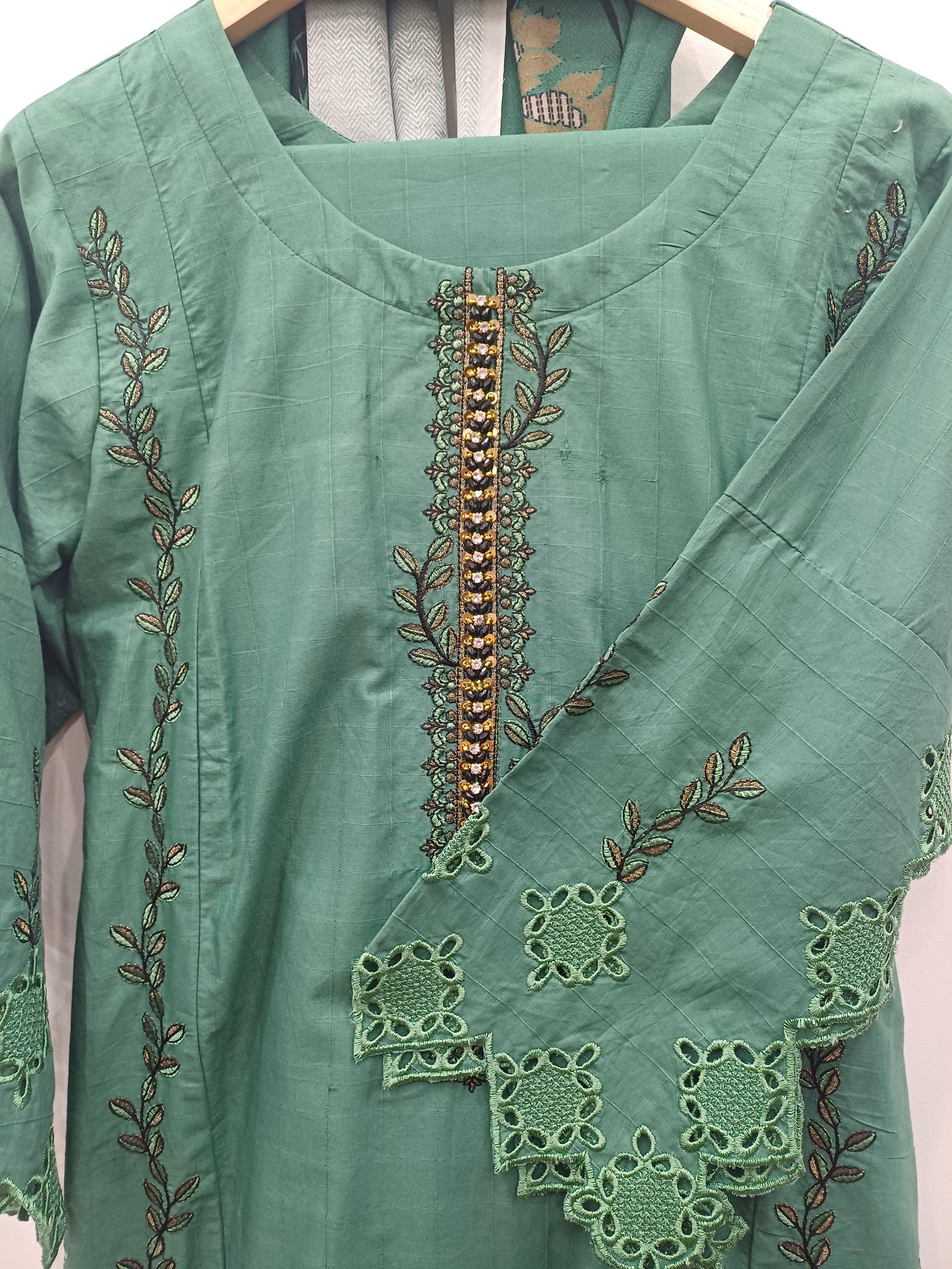 Close-up embroidery and cutwork sleeves on green cotton kurta