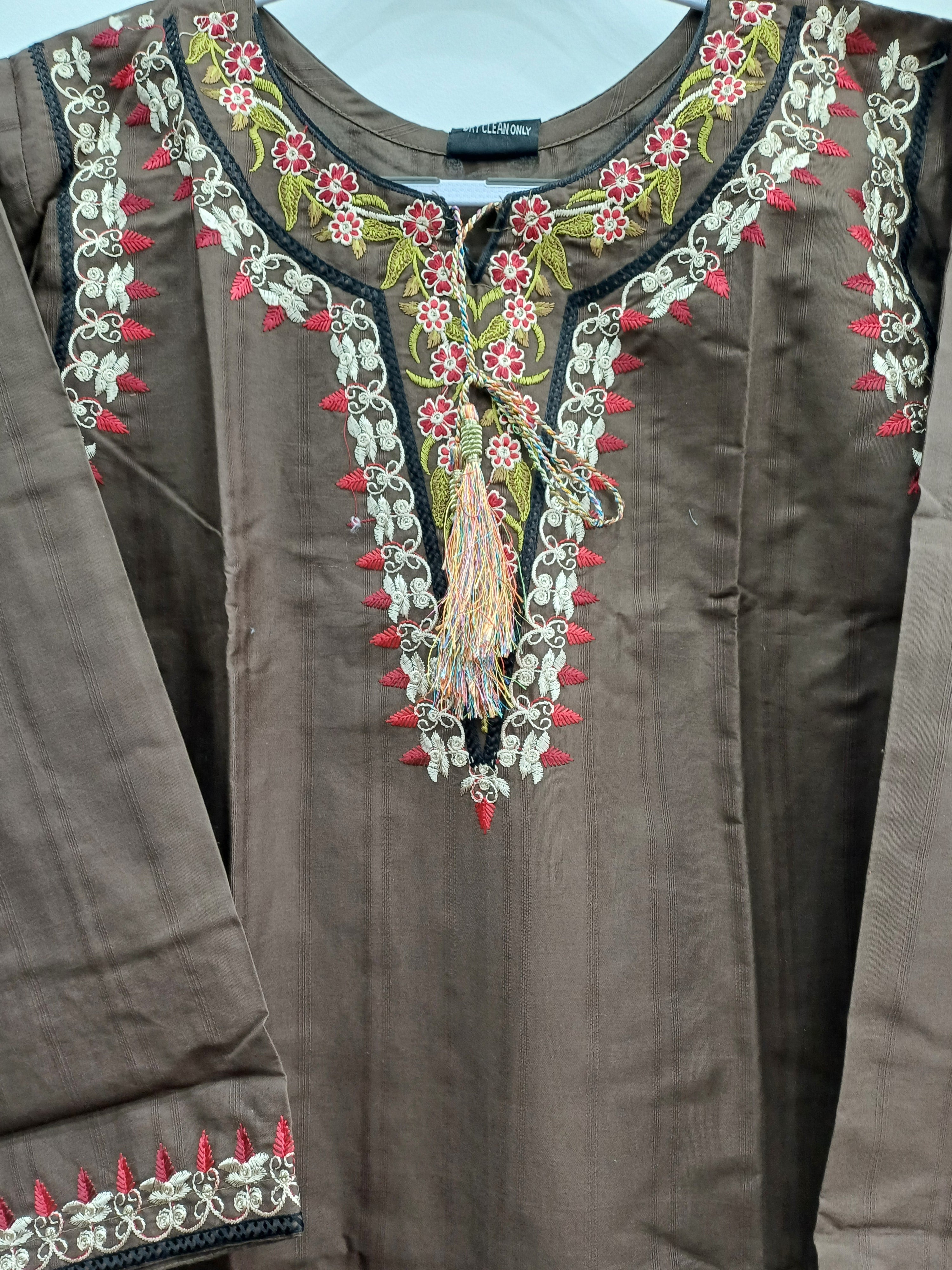 Close-up of neckline embroidery with tassels on winter cotton shirt