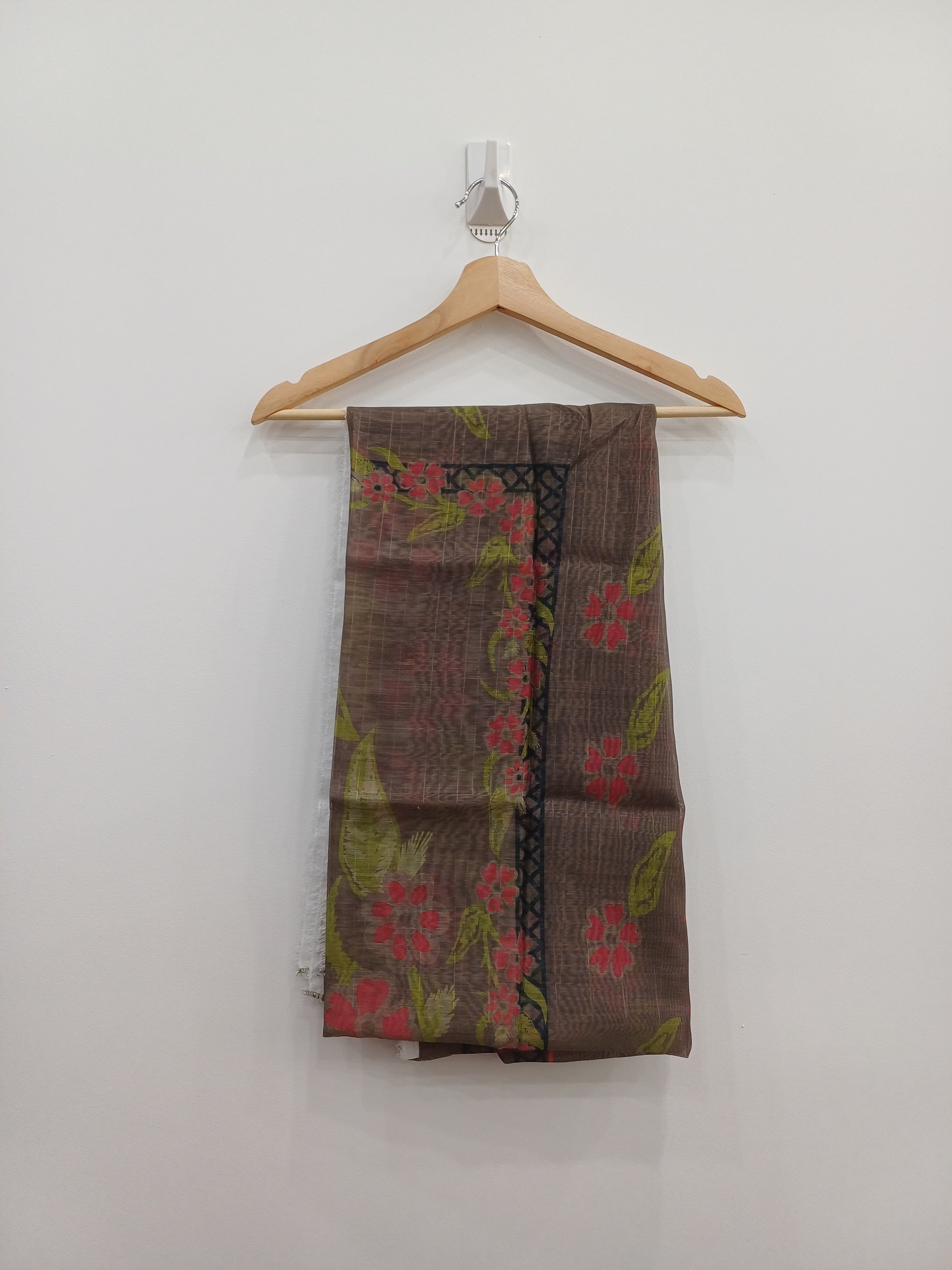 Brown fabric with floral pattern on a wooden hanger against a white background