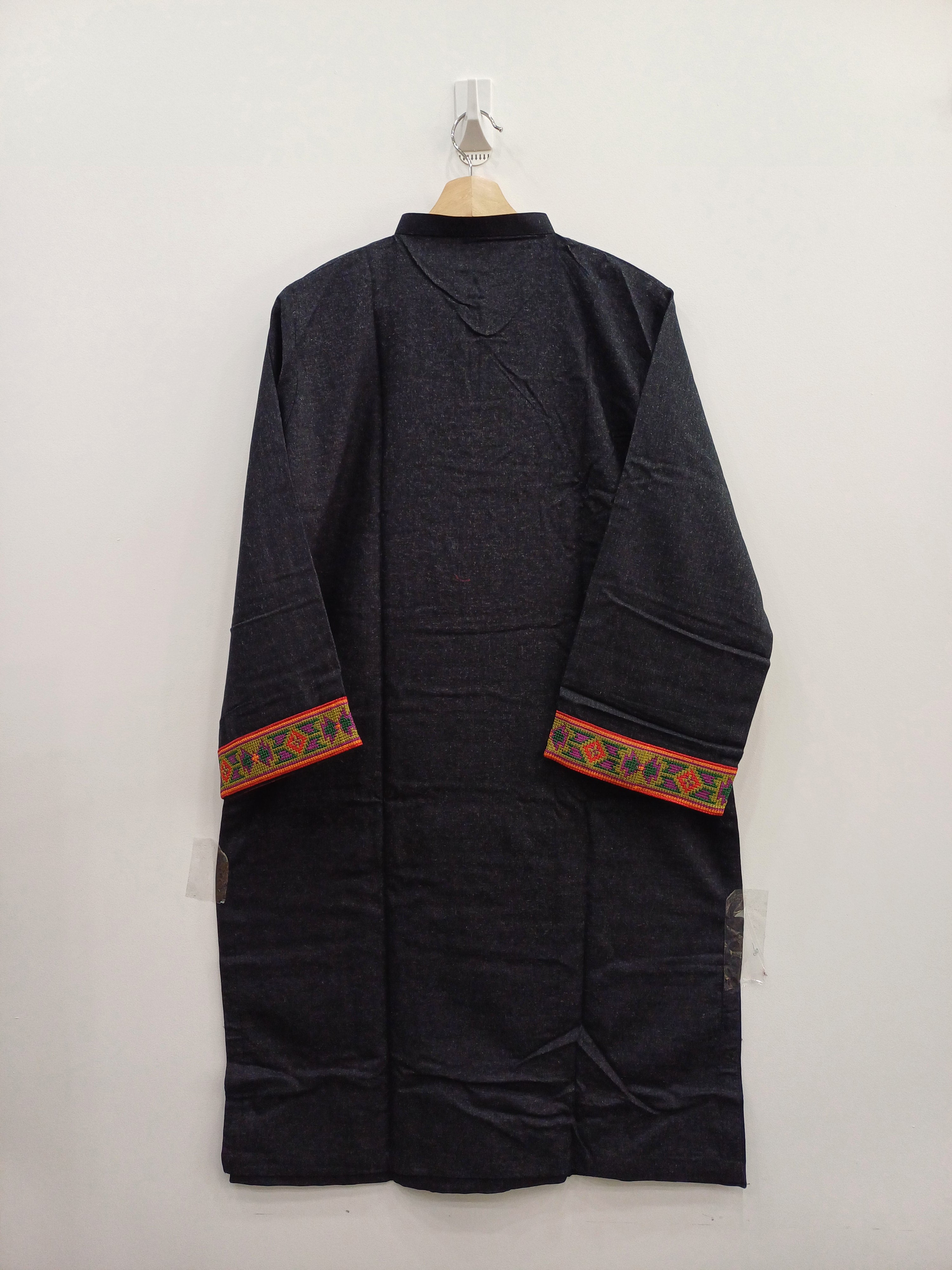 Dark-colored garment with decorative orange and green bands on a white background