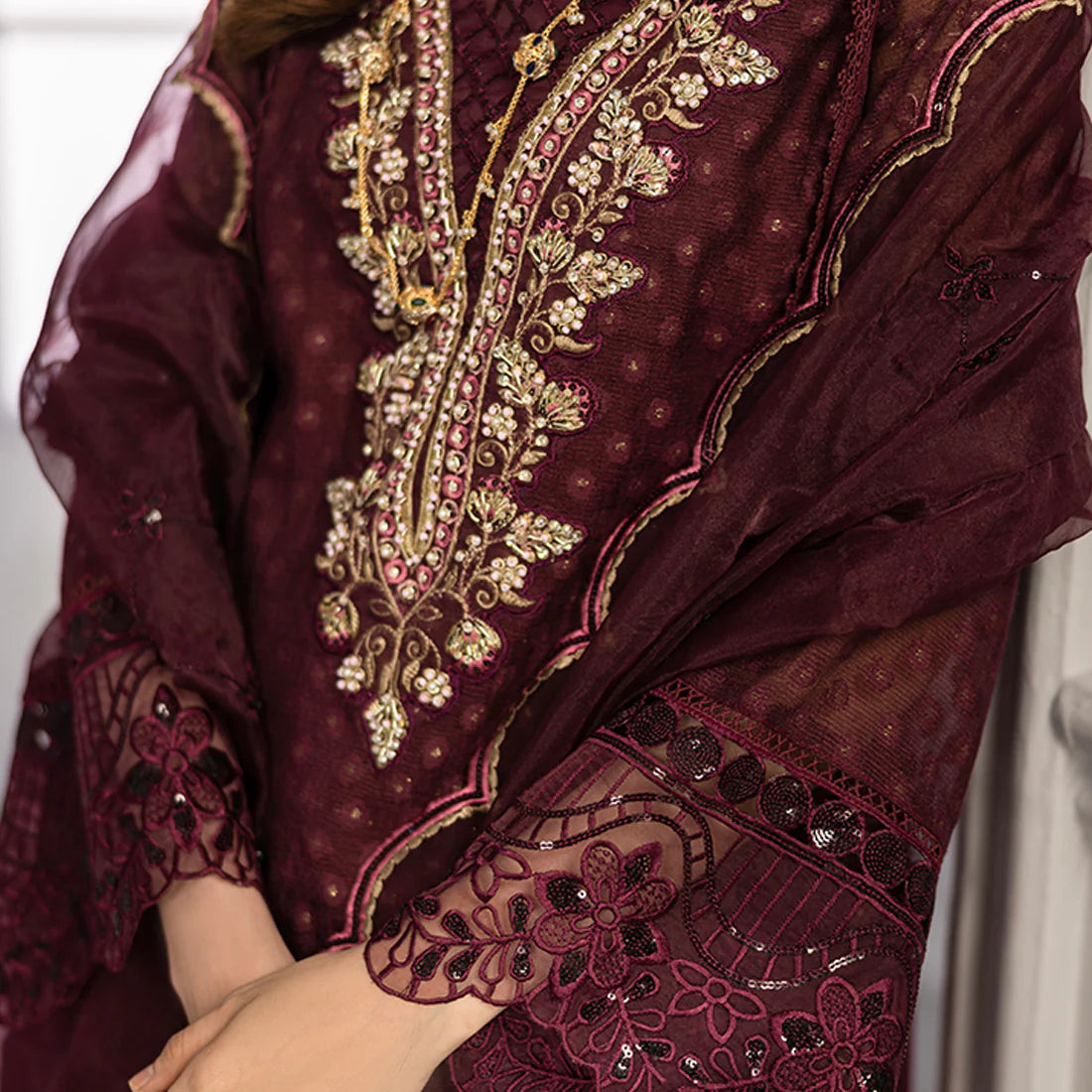 Plum base hand-embellished cotton net shirt with embroidered border, organza dupatta with finished pallu, and Russian Grip trouser