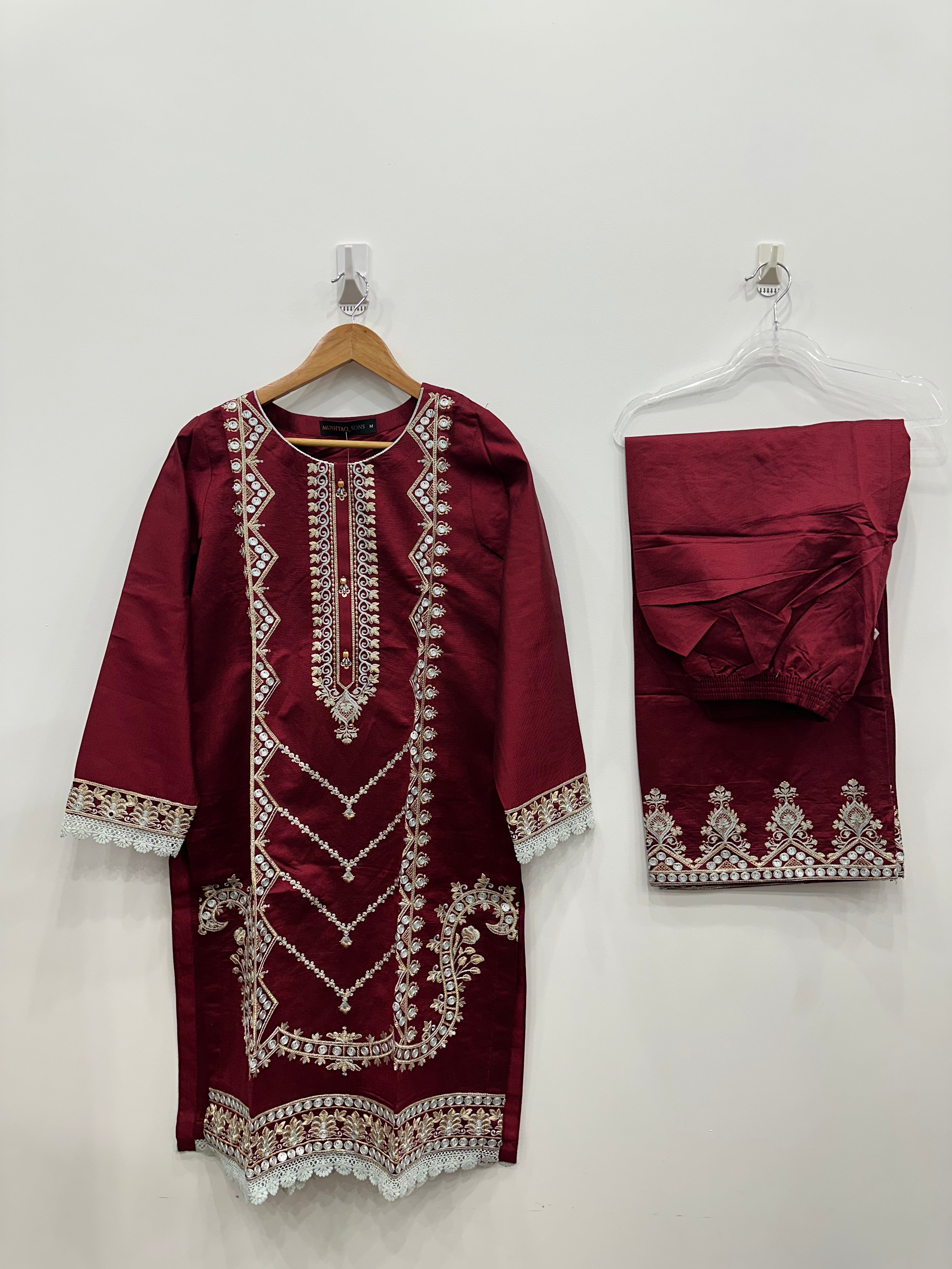 Full view of red khaddi net embroidered kurta and matching trousers