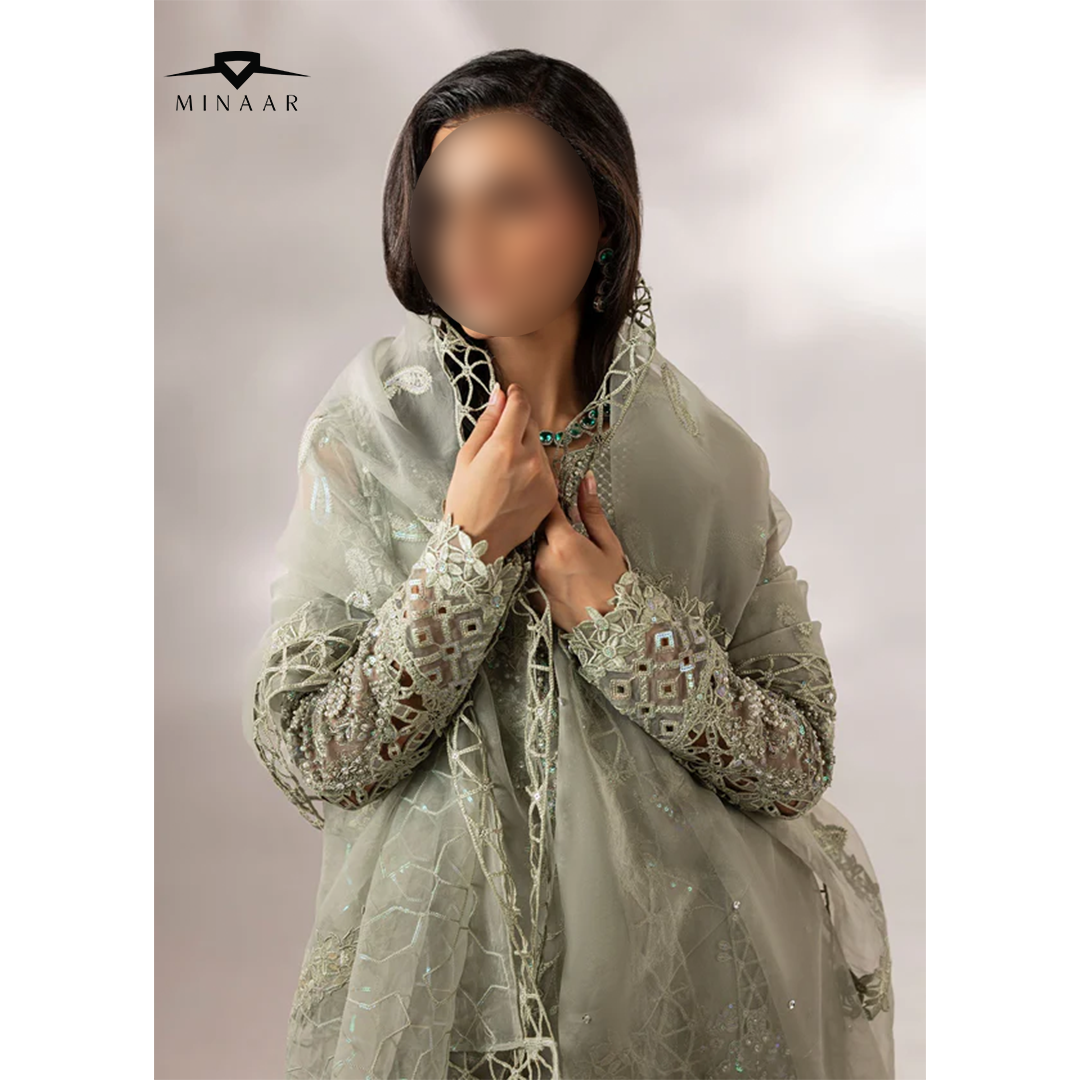 Person wearing a light green embroidered traditional outfit with 'Minaar' branding.