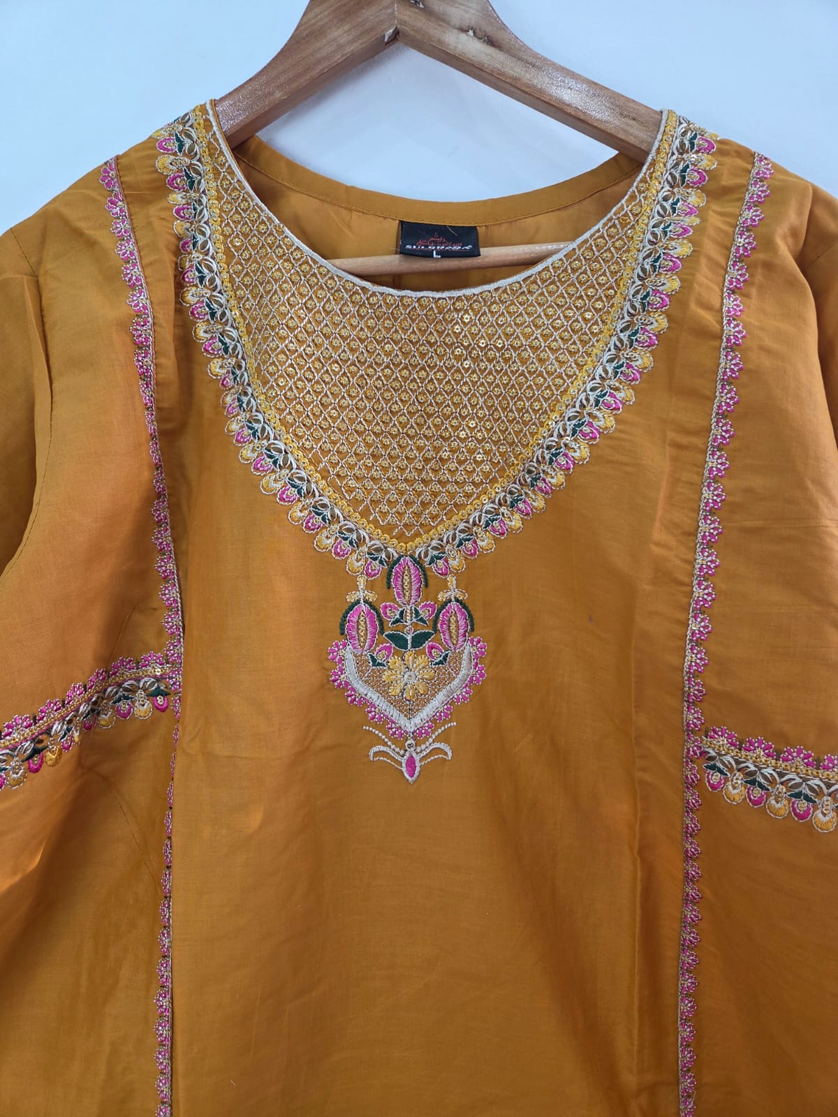 Mustard cotton lawn shirt with pink embroidery and tila work, paired with diamond dupatta