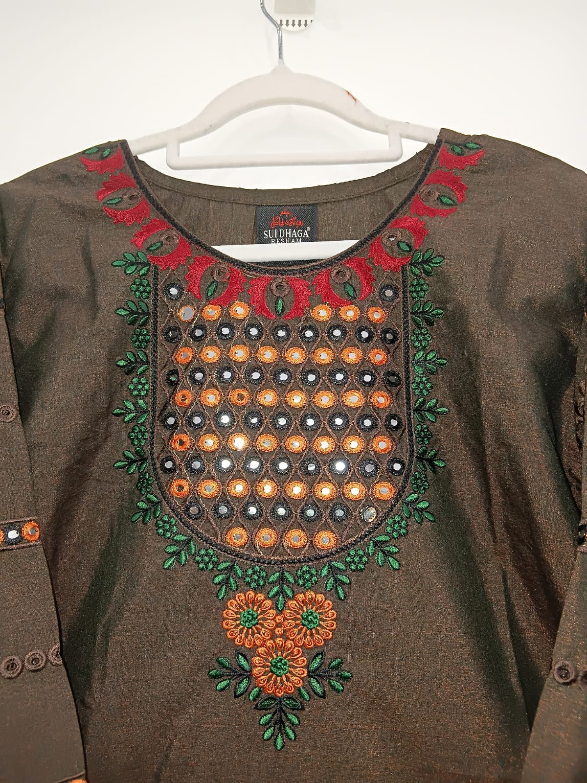 Brown shirt with intricate embroidery on a white background