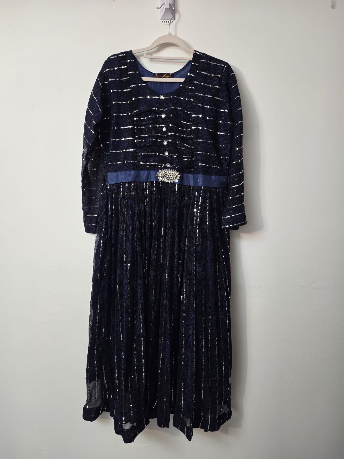 Navy blue full length sequin shimmer maxi dress with long sleeves, decorative buttons and crystal embellished waist detail