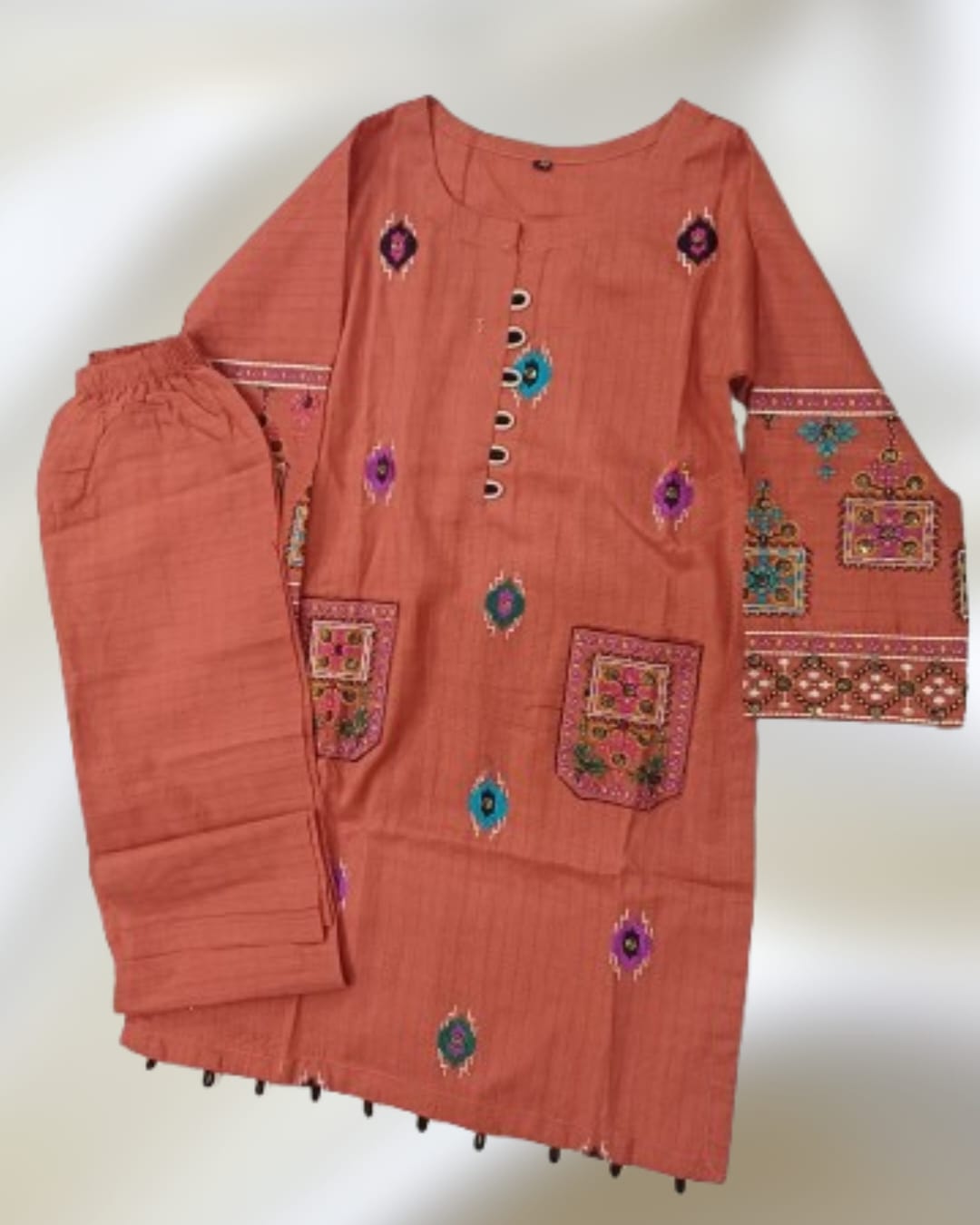 Peach 2 piece girls Pakistani suit with multicolor embroidered kurta, embroidered pockets and matching trouser