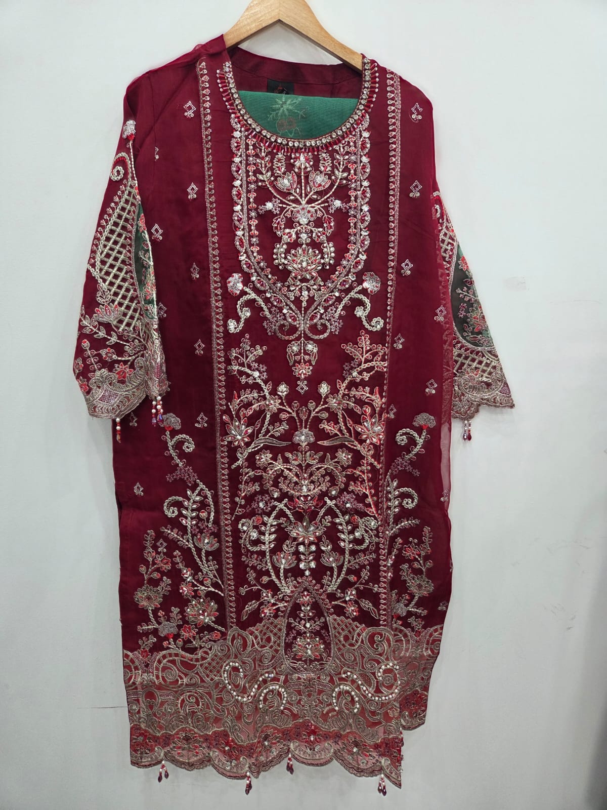 Red organza Pakistani 3 piece suit with heavy embroidery, stone work, green Khaddi Net dupatta and raw silk trouser