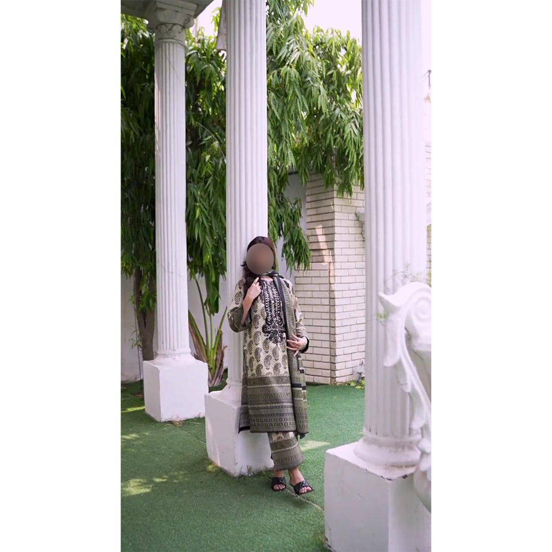 Person taking a mirror selfie in an outdoor setting with white columns and greenery.